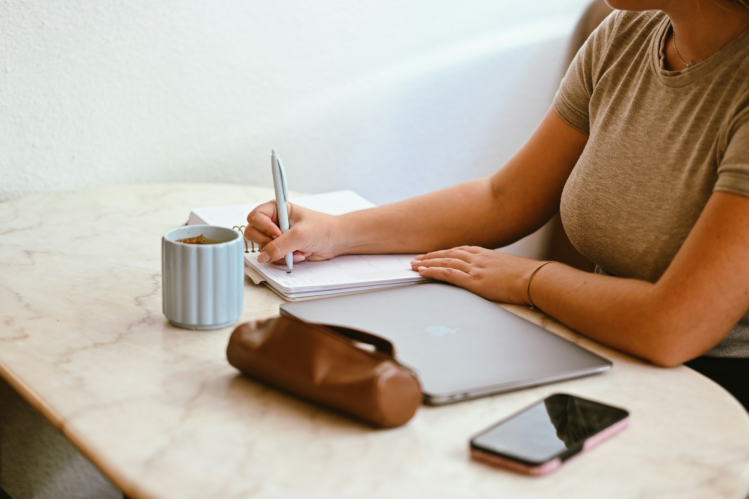 Writing in a planner at a table